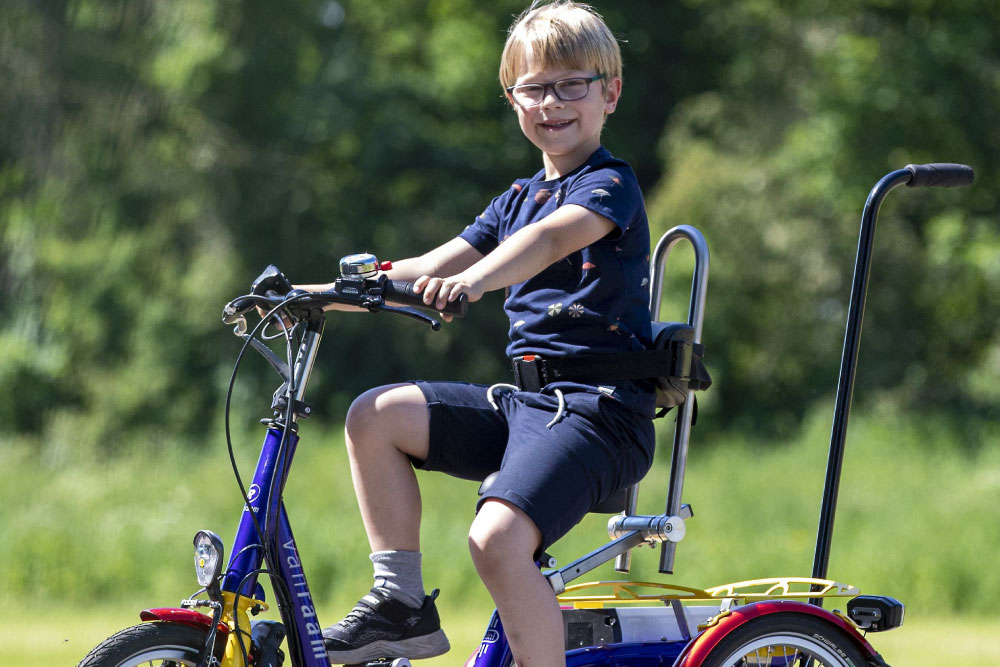Ein Junge fährt mit einem Dreirad von Van Raam