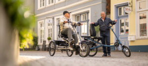 Zwei Herren fahren auf ihren Dreirädern durch die Stadt